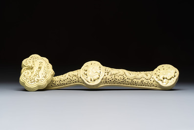 A large Chinese lemon-yellow-glazed biscuit 'Dragons' ruyi in the style of Wang Bingrong, on a wooden stand, Republic