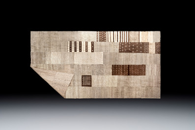 A very large Persian hand-knotted wool carpet with a geometric patchwork design, 20th C.