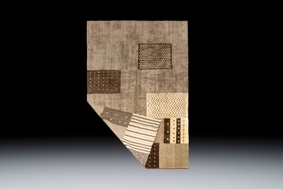 A large Persian hand-knotted wool carpet with a geometric patchwork design, 20th C.