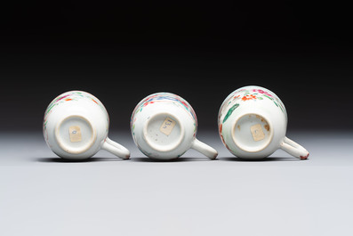 A Chinese famille rose teapot and cover with floral design and three cups, Qianlong