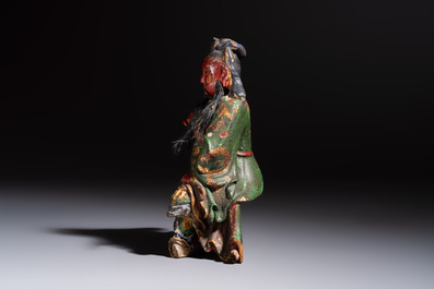 A Chinese gilt and polychrome lacquered papier-m&acirc;ch&eacute; and wooden Guandi on a wooden stand, 19th C.