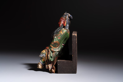 A Chinese gilt and polychrome lacquered papier-m&acirc;ch&eacute; and wooden Guandi on a wooden stand, 19th C.