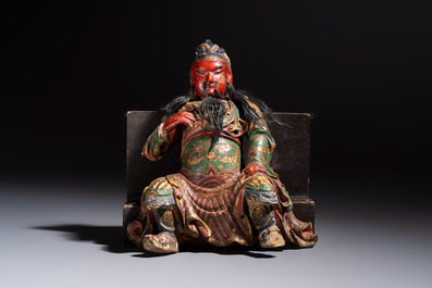 A Chinese gilt and polychrome lacquered papier-m&acirc;ch&eacute; and wooden Guandi on a wooden stand, 19th C.