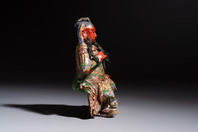 A Chinese gilt and polychrome lacquered papier-m&acirc;ch&eacute; and wooden Guandi on a wooden stand, 19th C.