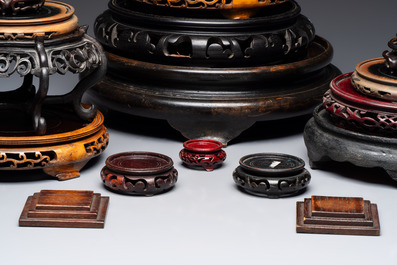 A Chinese reticulated wooden cover and 17 wooden stands, 19/20th C.