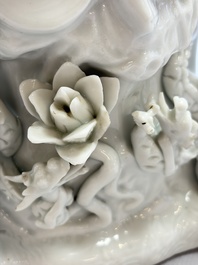 A pair of Chinese Dehua blanc de Chine groups of Guanyin with a child and servants, 18th C.