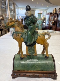 A pair of Chinese sancai-glazed 'Horseriders' roof tiles on wooden stands, Ming