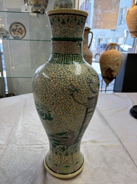 A Chinese verte biscuit 'Dragon Gate Carp 鯉躍龍門' vase on a wooden stand, Xuande mark, 19th C.