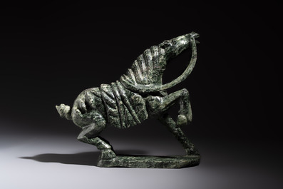 A large Chinese carved serpentine horse on a wooden stand, 20th C.