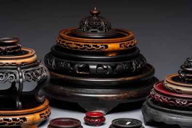 A Chinese reticulated wooden cover and 17 wooden stands, 19/20th C.