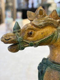 A pair of Chinese sancai-glazed 'Horseriders' roof tiles on wooden stands, Ming