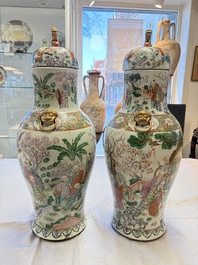 A pair of Chinese famille rose '18 Luohan' vases and covers, 19th C.