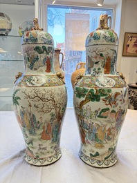 A pair of Chinese famille rose '18 Luohan' vases and covers, 19th C.