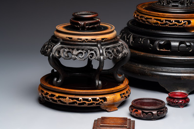 A Chinese reticulated wooden cover and 17 wooden stands, 19/20th C.