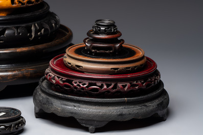 A Chinese reticulated wooden cover and 17 wooden stands, 19/20th C.