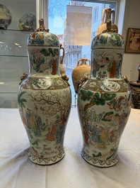 A pair of Chinese famille rose '18 Luohan' vases and covers, 19th C.