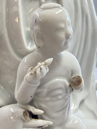 A pair of Chinese Dehua blanc de Chine groups of Guanyin with a child and servants, 18th C.