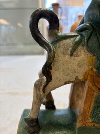 A pair of Chinese sancai-glazed 'Horseriders' roof tiles on wooden stands, Ming