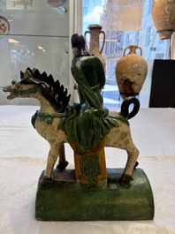 A pair of Chinese sancai-glazed 'Horseriders' roof tiles on wooden stands, Ming