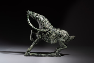 A large Chinese carved serpentine horse on a wooden stand, 20th C.