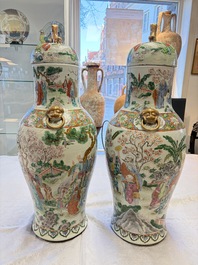 A pair of Chinese famille rose '18 Luohan' vases and covers, 19th C.