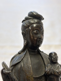 A Chinese bronze standing Guanyin with boy, Ming