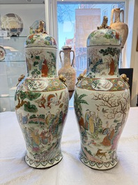 A pair of Chinese famille rose '18 Luohan' vases and covers, 19th C.