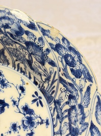 Eleven Chinese blue and white gadrooned 'Flowers and Peacocks' plates, Kangxi