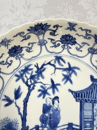 A Chinese blue and white 'Elegant Lady with Two Boys' plate with a 'Lotus Scroll' border, Kangxi