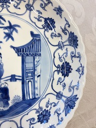 A Chinese blue and white 'Elegant Lady with Two Boys' plate with a 'Lotus Scroll' border, Kangxi