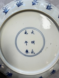 A Chinese blue and white 'Elegant Lady with Two Boys' plate with a 'Lotus Scroll' border, Kangxi
