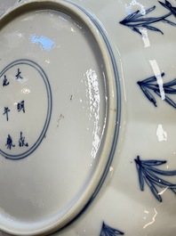 A Chinese blue and white 'Elegant Lady with Two Boys' plate with a 'Lotus Scroll' border, Kangxi