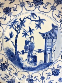 A Chinese blue and white 'Elegant Lady with Two Boys' plate with a 'Lotus Scroll' border, Kangxi