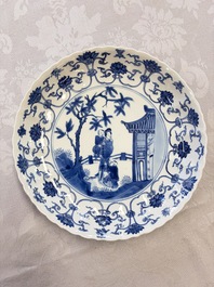 A Chinese blue and white 'Elegant Lady with Two Boys' plate with a 'Lotus Scroll' border, Kangxi
