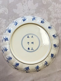 A Chinese blue and white 'Elegant Lady with Two Boys' plate with a 'Lotus Scroll' border, Kangxi