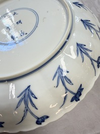 A Chinese blue and white 'Elegant Lady with Two Boys' plate with a 'Lotus Scroll' border, Kangxi
