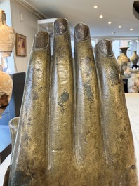 A rare and large Tibetan bronze forearm of a Buddhist figure with a chakra design, on a later metal stand, Qing