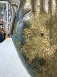 A rare and large Tibetan bronze forearm of a Buddhist figure with a chakra design, on a later metal stand, Qing