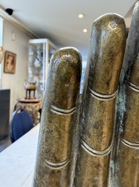 A rare and large Tibetan bronze forearm of a Buddhist figure with a chakra design, on a later metal stand, Qing