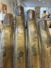 A rare and large Tibetan bronze forearm of a Buddhist figure with a chakra design, on a later metal stand, Qing