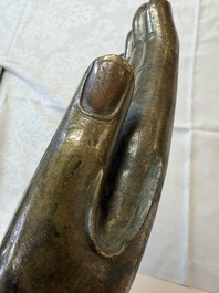 A rare and large Tibetan bronze forearm of a Buddhist figure with a chakra design, on a later metal stand, Qing