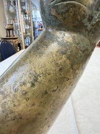 A rare and large Tibetan bronze forearm of a Buddhist figure with a chakra design, on a later metal stand, Qing