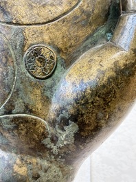 A rare and large Tibetan bronze forearm of a Buddhist figure with a chakra design, on a later metal stand, Qing