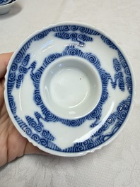 A pair of Chinese inscribed blue and white 'Clouds' tea bowls, covers and stands, Guangxu mark and of the period