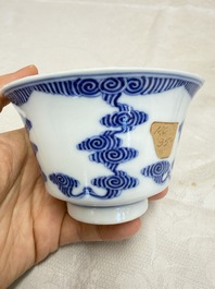 A pair of Chinese inscribed blue and white 'Clouds' tea bowls, covers and stands, Guangxu mark and of the period