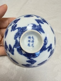 A pair of Chinese inscribed blue and white 'Clouds' tea bowls, covers and stands, Guangxu mark and of the period
