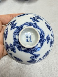 A pair of Chinese inscribed blue and white 'Clouds' tea bowls, covers and stands, Guangxu mark and of the period