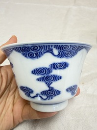 A pair of Chinese inscribed blue and white 'Clouds' tea bowls, covers and stands, Guangxu mark and of the period