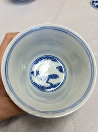 A pair of Chinese inscribed blue and white 'Clouds' tea bowls, covers and stands, Guangxu mark and of the period
