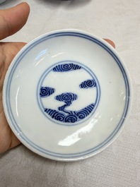 A pair of Chinese inscribed blue and white 'Clouds' tea bowls, covers and stands, Guangxu mark and of the period